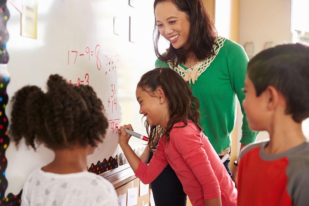 teacher will first grade students writing on whiteboard; national teacher awards concept