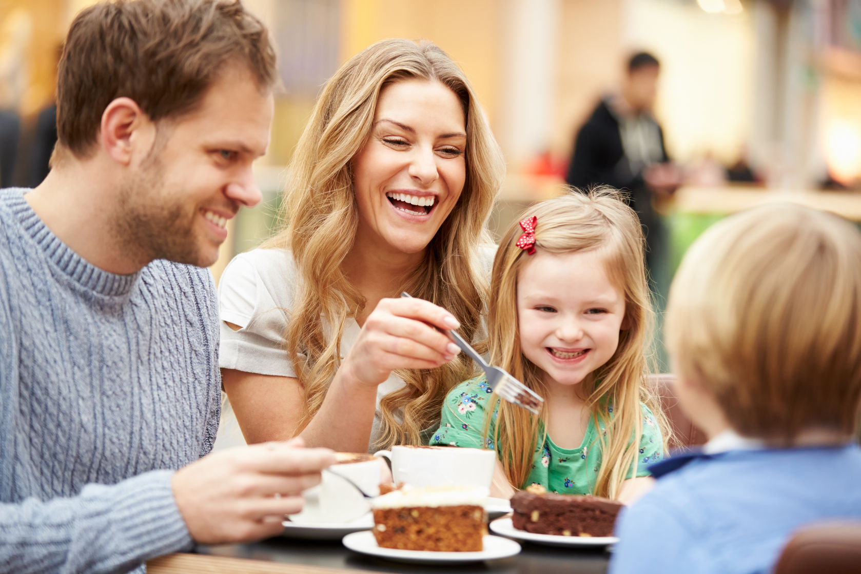 family enjoying snack in cafe together