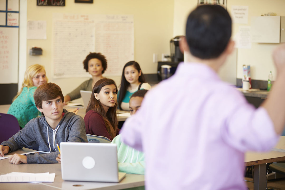 High School Students With Teacher In Class Using Laptops