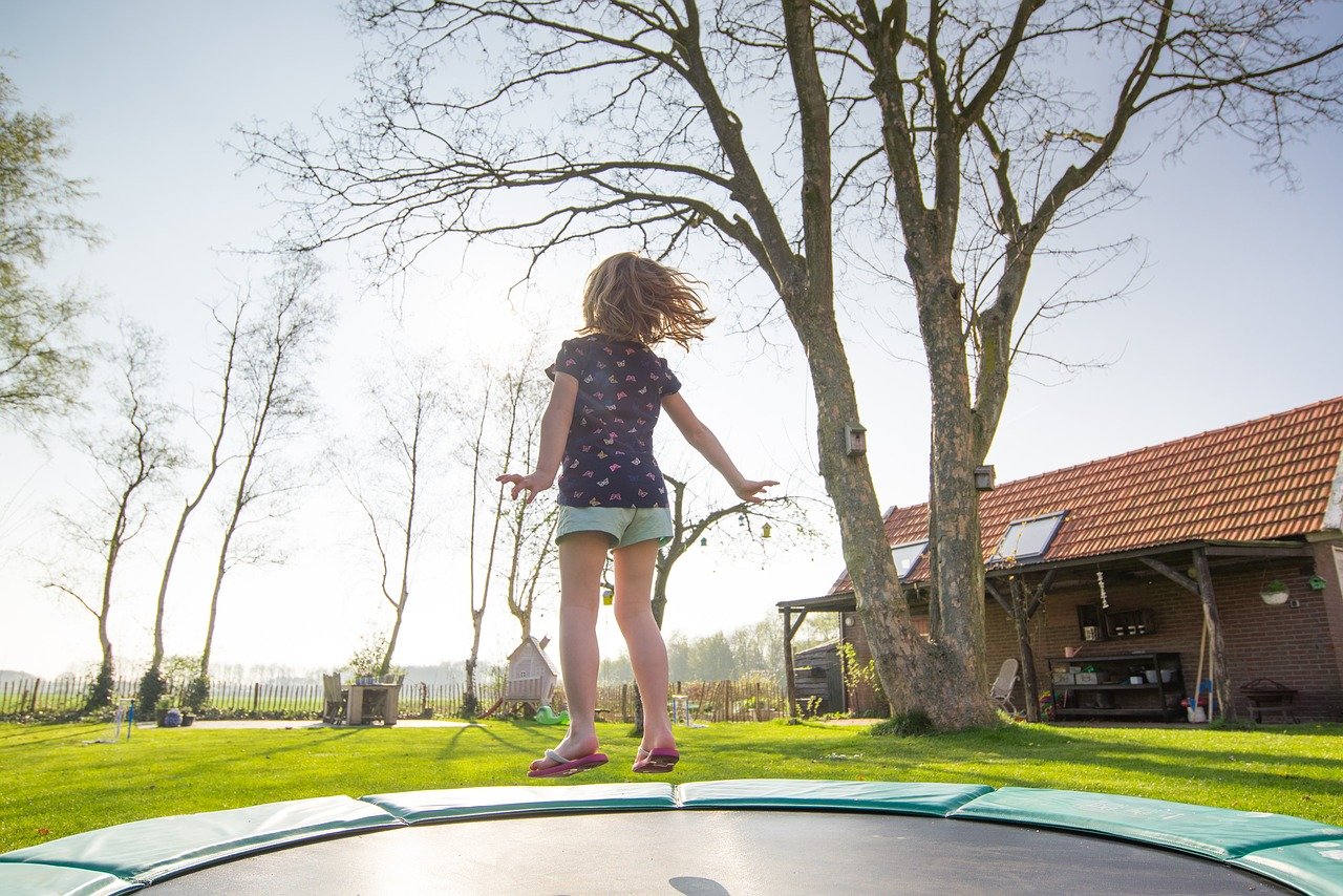 Child bounces on a trampoline; PE remote learning concept