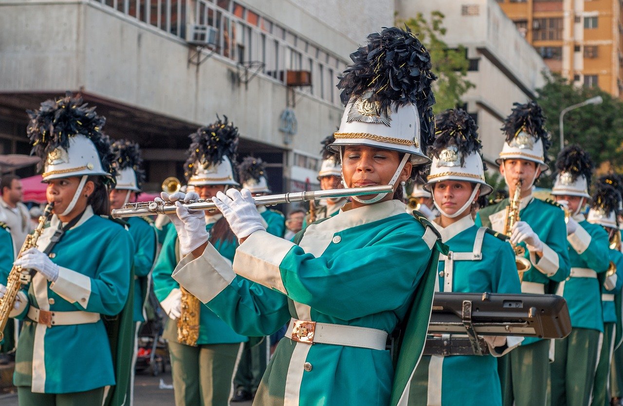 student marching band in bright uniforms; concept: safe return of arts programs