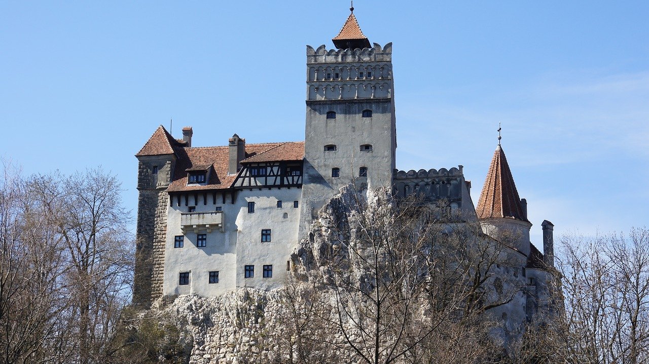 a white stone castle on a hilltop in autumn; halloween classic literature concept