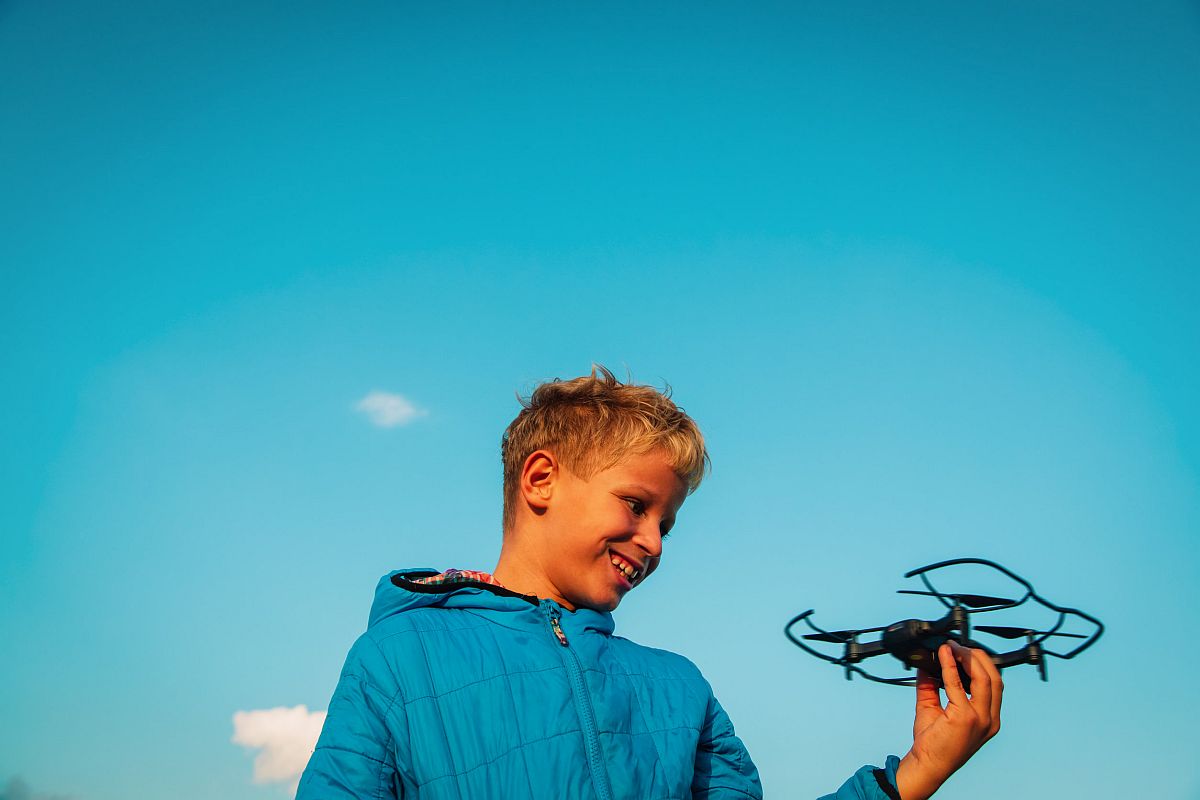 Young boy enjoy playing with drone in nature; drones lesson plans concept
