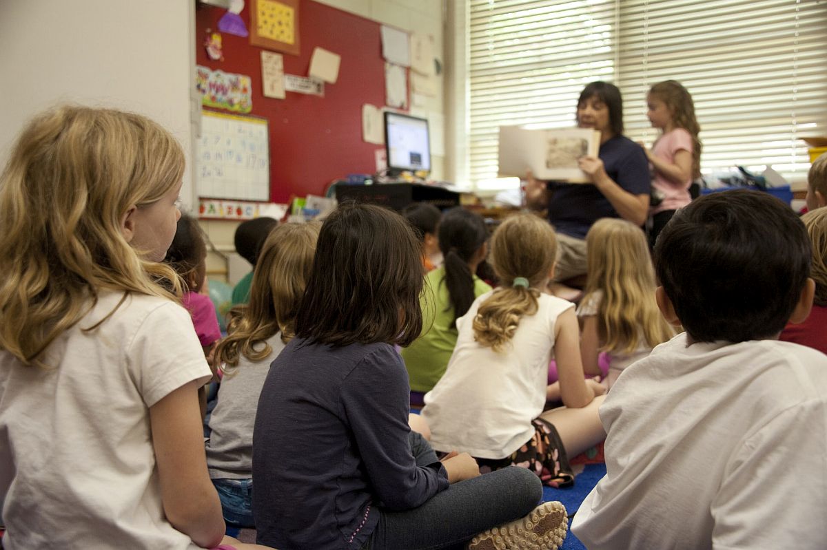 teacher reading to attentive young students; schoolwide events concept