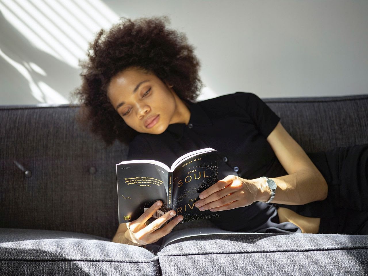 student reading on a couch; teaching analytical reading concept