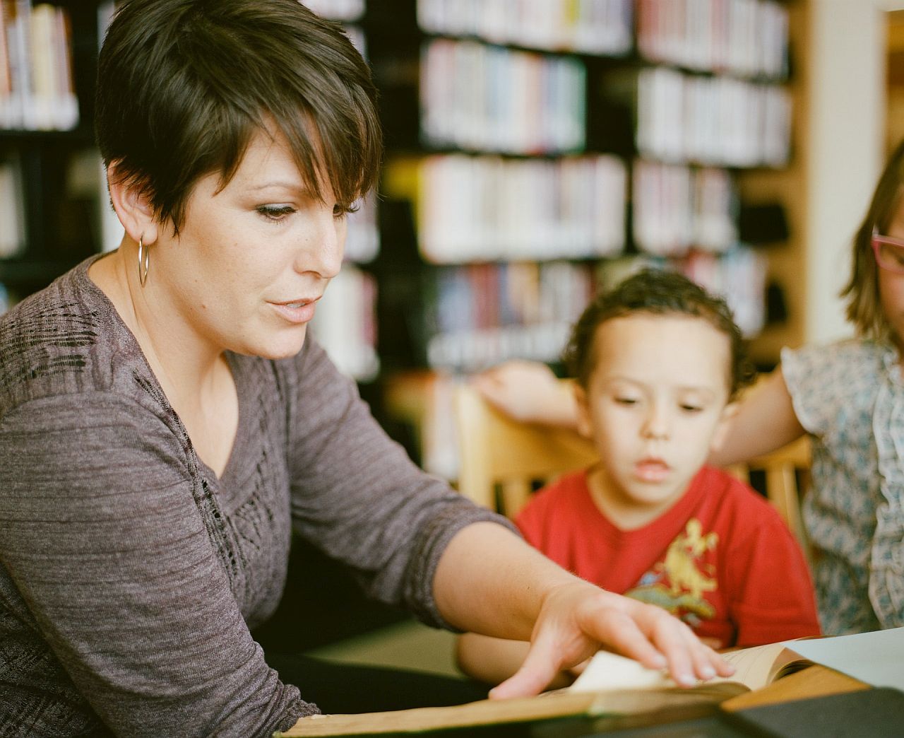 teacher reading to student in a library; differentiated lesson plans concept