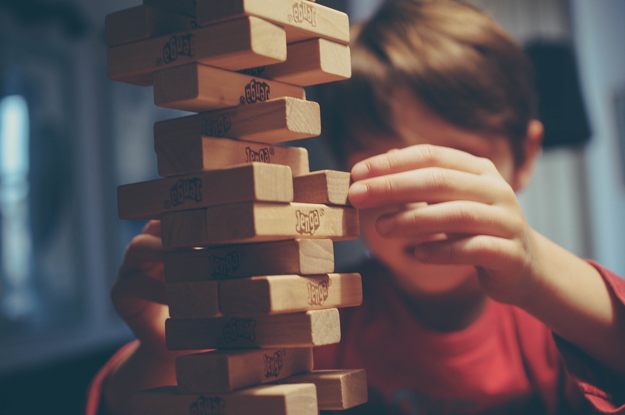 young student stacking blocks; indoor recess concept