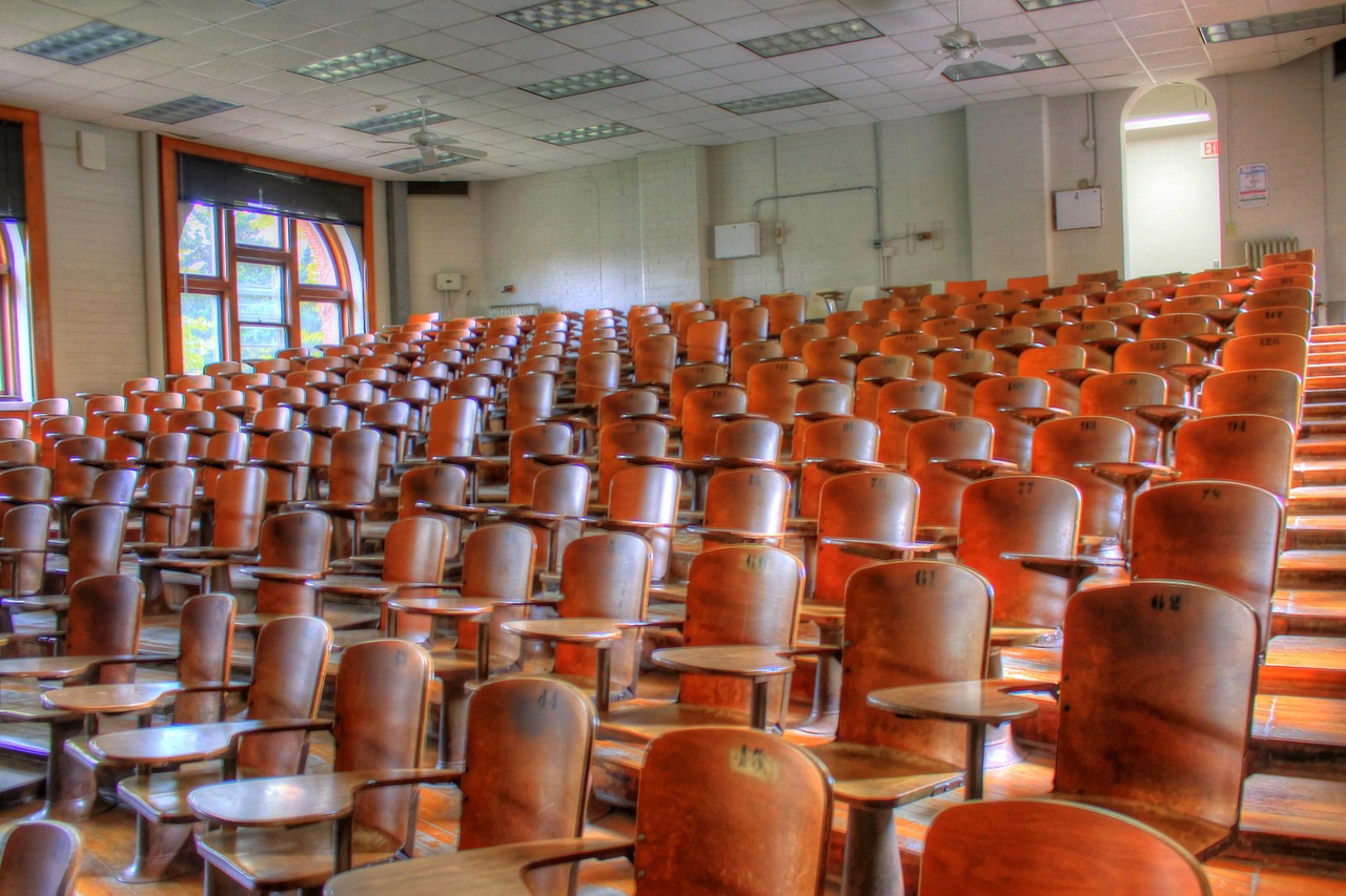 very large empty lecture hall; overcrowded classroom concept