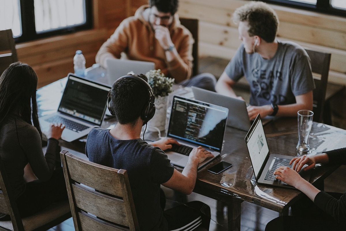 college students on laptops share a table; group projects concept