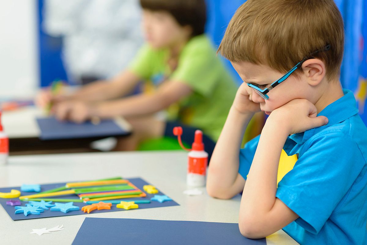 Angry kid looking at his craft at kindergarten; self-calming strategies for students concept