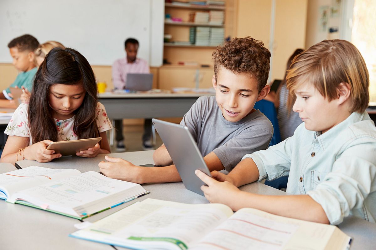 young students use a tablet in a classroom; government lesson plans concept