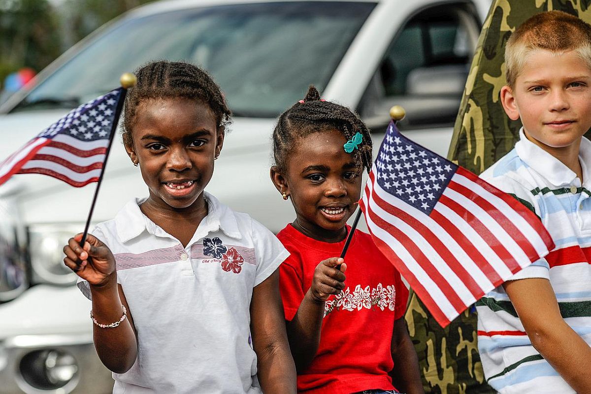 Children waving American flags; voting lesson plans concept