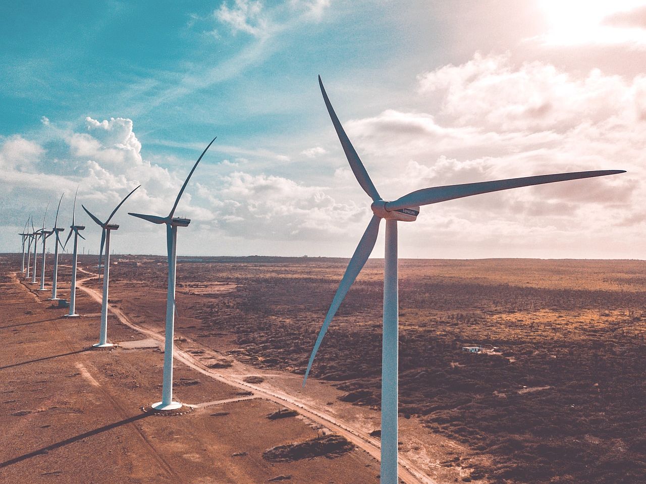 Row of wind turbines in arid landscape; renewable energy lesson plans concept