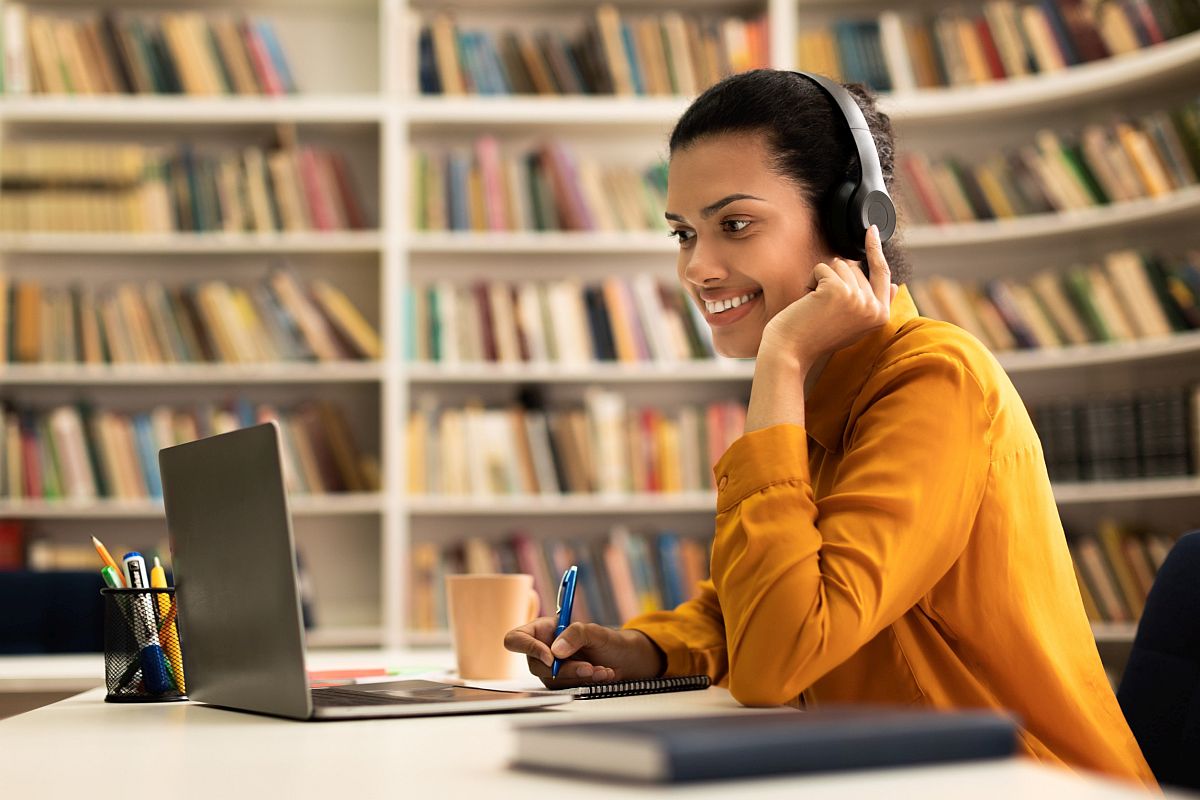 Smiling person working on laptop; nano-learning concept.