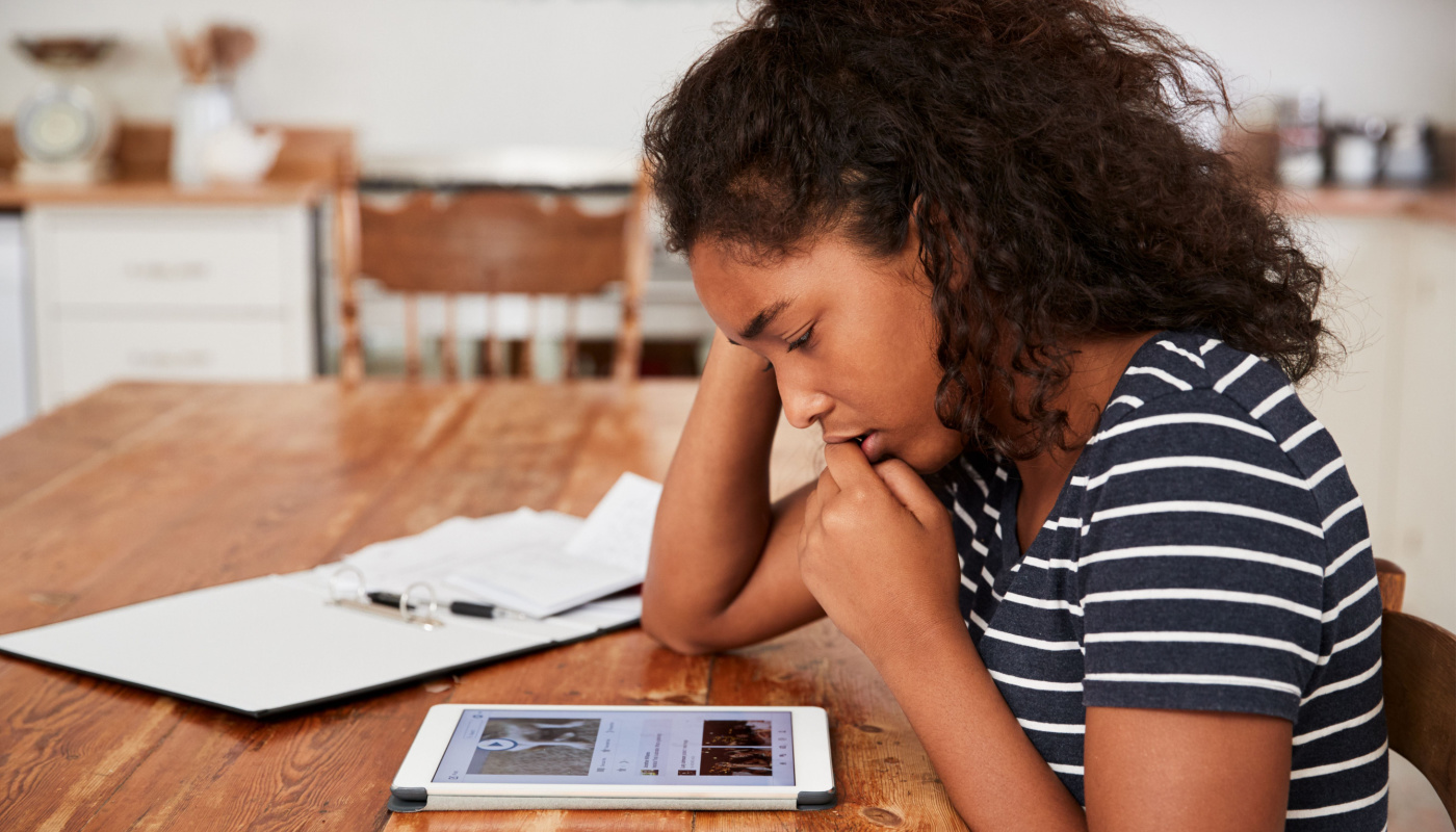 Worried girl, looking at social media posts; social media and body image concept 