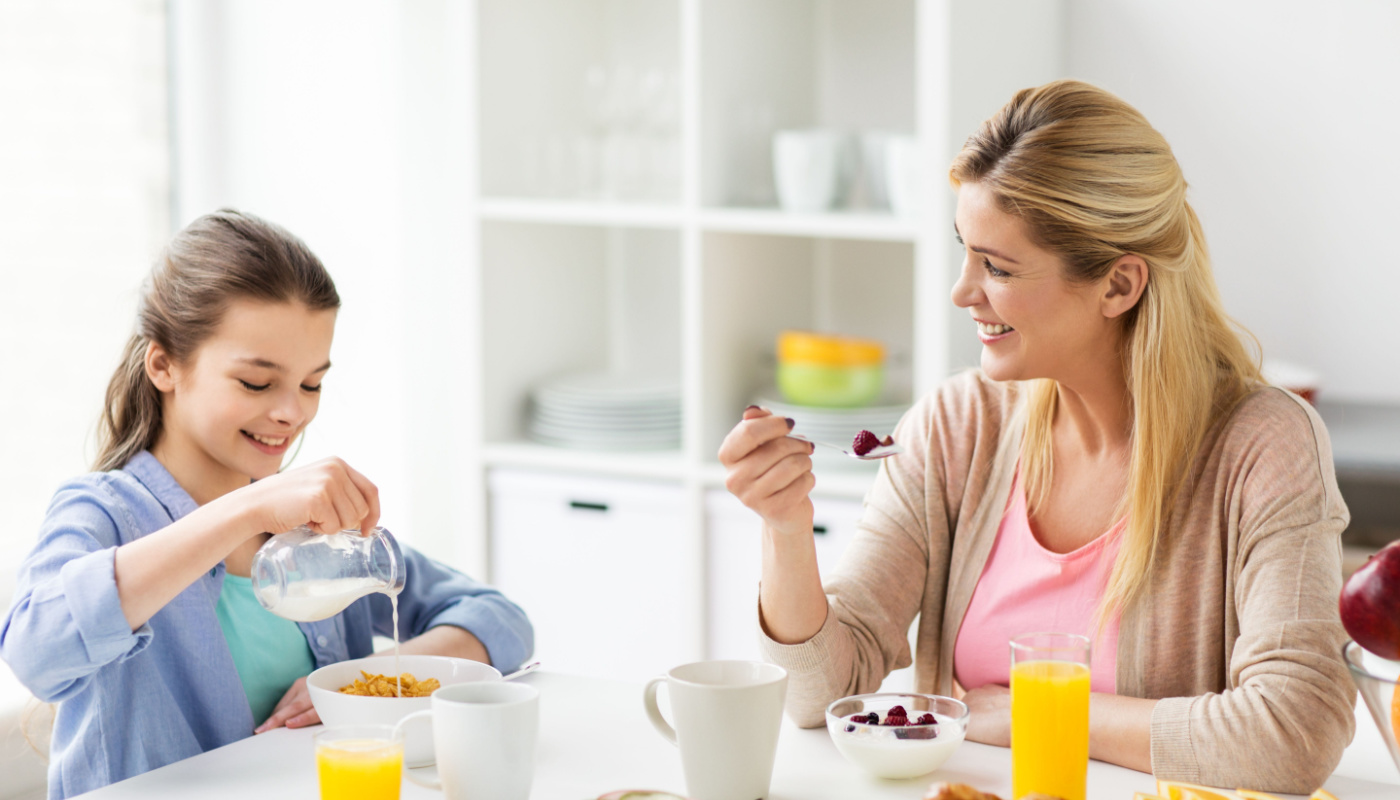 Child and mother eating breakfast together; later school start times concept